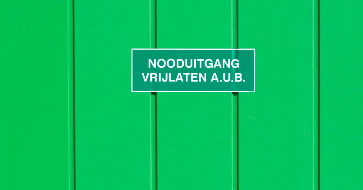 A green metal wall featuring an emergency exit sign in Dutch. Perfect for safety-themed graphics.